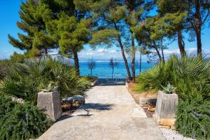 a walkway with trees and a view of the water at Holiday House de Finis in Sutivan