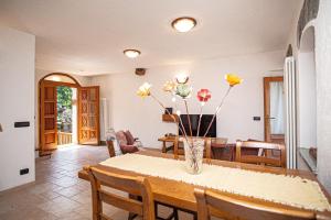 a dining room with a table with flowers in a vase at Lo Berio CIR 0071 in Saint Vincent