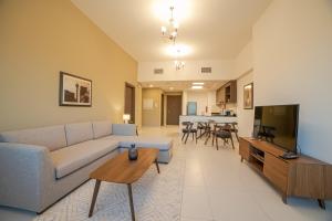 a living room with a couch and a tv at ABIDOS HOLIDAY HOMES Windsor Residence in Dubai