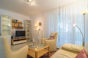 ein Wohnzimmer mit einem Sofa und einem TV in der Unterkunft Villa Darja - Ferienwohnung Meerblick in Heringsdorf