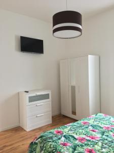 a bedroom with a bed and a dresser and a tv at Casa De Angelis in Castellanza