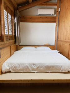 Cama grande en habitación con paredes de madera en 小島上二館, en Chung-liu-ts'un