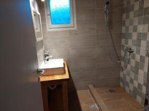 a bathroom with a sink and a shower with a window at Amelia's Garden in Kavos