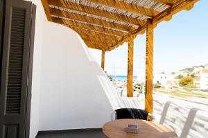 einen Tisch und Stühle auf einem Balkon mit Meerblick in der Unterkunft ANDROMEDA in Kalymnos