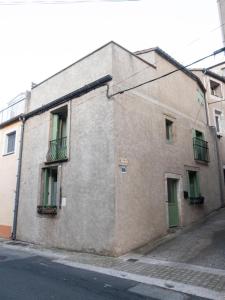 a brick building with a green door and windows at Maison d’Paula in Avène