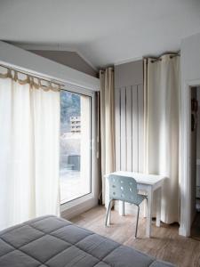 a bedroom with a bed and a desk and a window at Maison d’Paula in Avène