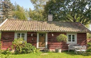 a small wooden house with a bench in the yard at Beautiful Home In Eskilstuna With Sauna And Wifi in Eskilstuna