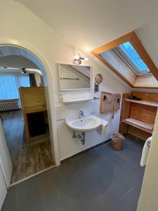 ein Bad mit einem Waschbecken und einem Spiegel in der Unterkunft Gästehaus Alpvital in Klais
