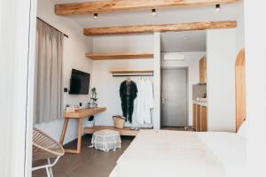 sypialnia z łóżkiem, biurkiem i telewizorem w obiekcie ANDROMEDA w mieście Kalimnos