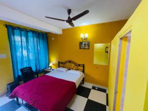 1 dormitorio con 1 cama grande y paredes amarillas en Samantha Inn Beach Resort, en Arambol