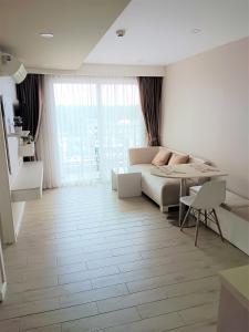 a white living room with a bed and a table at Seven Seas Condo Resort Beautiful Location in Jomtien Beach