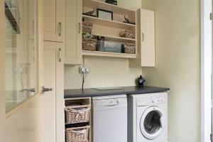 - une buanderie avec un lave-linge et un sèche-linge dans l'établissement Miners Cottage, à Blaenau Ffestiniog