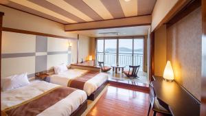 土庄町にある天空ホテル 海廬のベッド2台とバルコニーが備わるホテルルームです。
