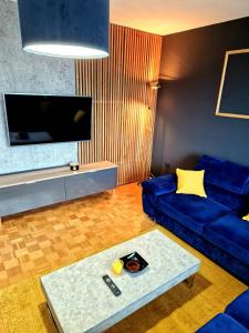 - un salon avec un canapé bleu et une table dans l'établissement Stan na dan Koprivnica-Comfort, à Koprivnica