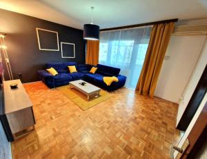 sala de estar con sofá azul y almohadas amarillas en Stan na dan Koprivnica-Comfort, en Koprivnica