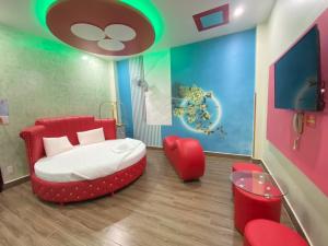um quarto com uma cama e uma cadeira vermelha em HOTEL THU HÀ em Ho Chi Minh