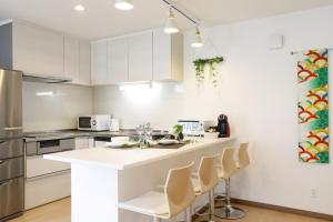a kitchen with white cabinets and a white counter top at AOI in Furano