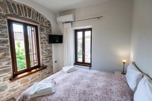 a bedroom with a large bed and two windows at Ιkia Zmas in Argalasti