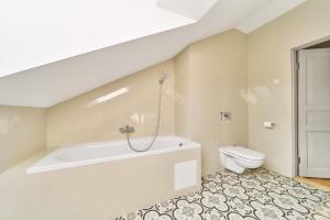 a bathroom with a bath tub and a toilet at Modern Two-Bedroom Apartment, Vilnius City Centre in Vilnius
