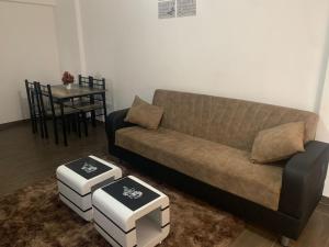 a living room with a couch and two stools at Oasis comfort in Nairobi