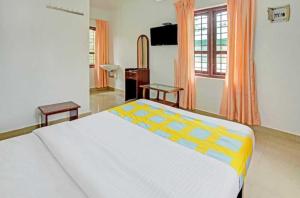 - une chambre avec un grand lit et une fenêtre dans l'établissement Mountain View cottage Mankulam, à Munnar