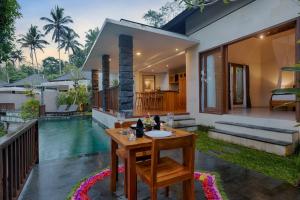 une maison avec une table et une piscine dans l'établissement Kelusa Hill, à Ubud