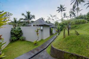 a villa with a garden and a house at Kelusa Hill in Ubud
