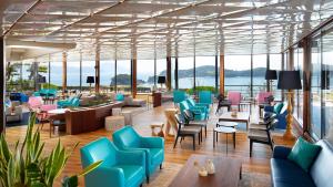 a lobby with blue and pink chairs and tables at Tenku Hotel Kairo in Tonosho