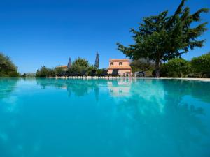 ein Pool mit blauem Wasser mit einem Haus im Hintergrund in der Unterkunft Eliathos Residence Houses in Archanes