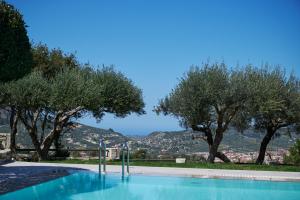 a swimming pool with trees and a mountain in the background at Eliathos Residence Houses in Archanes