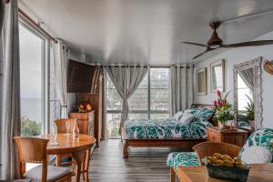 a bedroom with a bed and a table and chairs at Breezy Beachfront Bali-Style Haven 180 Degree OceanView in Hauula