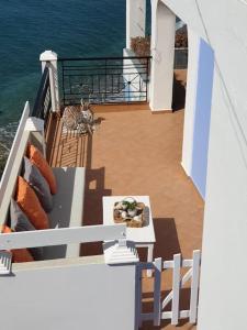 a cat sitting on a balcony with a table at Aegean Villa-On beach apartment! Ideal choice! in Masouri