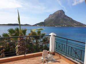 Dos pájaros sentados en un balcón con vistas a la montaña en Aegean Villa-On beach apartment! Ideal choice!, en Masouri