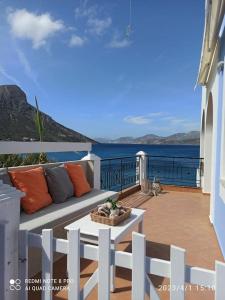 un sofá en un balcón con vistas al agua en Aegean Villa-On beach apartment! Ideal choice!, en Masouri