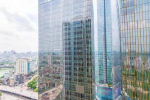 een hoog glazen gebouw met een stad op de achtergrond bij 22housing Vinhomes Metropolis Hotel & Apartment in Hanoi