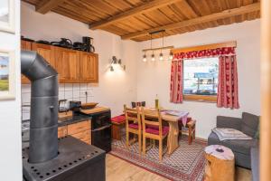 a kitchen and living room with a stove and a table at Hike & Bike Chalet in Bohinj