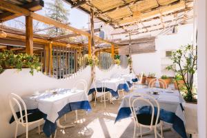 a restaurant with white tables and white chairs at Hotel Toro in Ravello