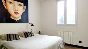 a bedroom with a large painting of a woman at Le Picard-Petit Quevilly in Le Petit-Quevilly