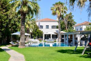 une maison avec une piscine et des palmiers dans l'établissement Elysian villa, à Spetses