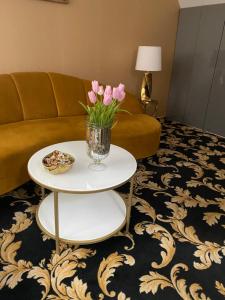 a living room with a couch and a table with flowers on it at Váralja Home in Budapest
