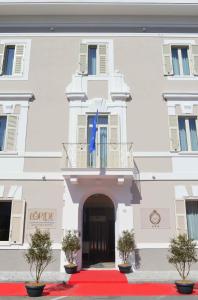 a building with a red carpet and a flag on it at Doride Suites Boutique Hotel in Marina di Carrara