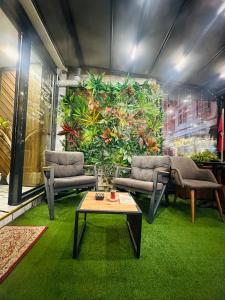 a room with chairs and a table and a large wall of plants at Sirkeci Quietness Hotel in Istanbul