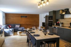 a kitchen and living room with a table with wine glasses at Gîte de la Ravanne in Ramonchamp