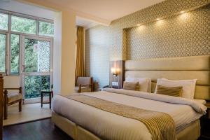 een hotelkamer met een groot bed en een raam bij Hotel Shiva Continental in Mussoorie