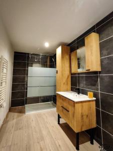 a bathroom with a sink and a shower at Gîte de la Ravanne in Ramonchamp