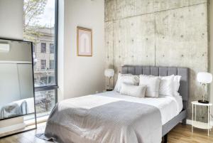 a bedroom with a large bed with a concrete wall at Downtown 1BR w Gym WD BBQ nr Nightlife SEA-366 in Seattle