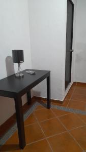 una mesa negra con una lámpara en una habitación en Posada El Refugio, en Mineral de Pozos