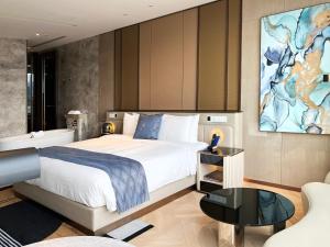 上海市にあるProdor Hotel Shanghaiのベッドルーム1室(ベッド1台付)が備わります。壁には大きな絵画が飾られています。
