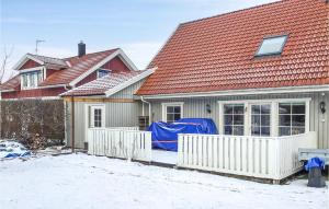 a house with a white fence in the snow at Cozy Apartment In Sigtuna With Wifi in Sigtuna