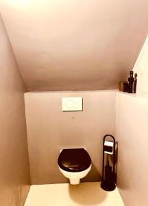 uma pequena casa de banho com WC e assento preto em Atelier Raamwerk City Apartments Deventer 125m2! em Deventer